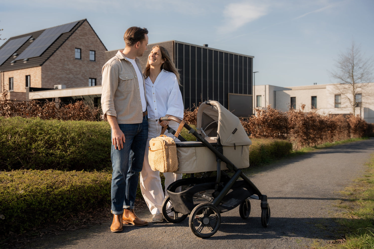 Organized nappy bag attached to a stroller during a family walk